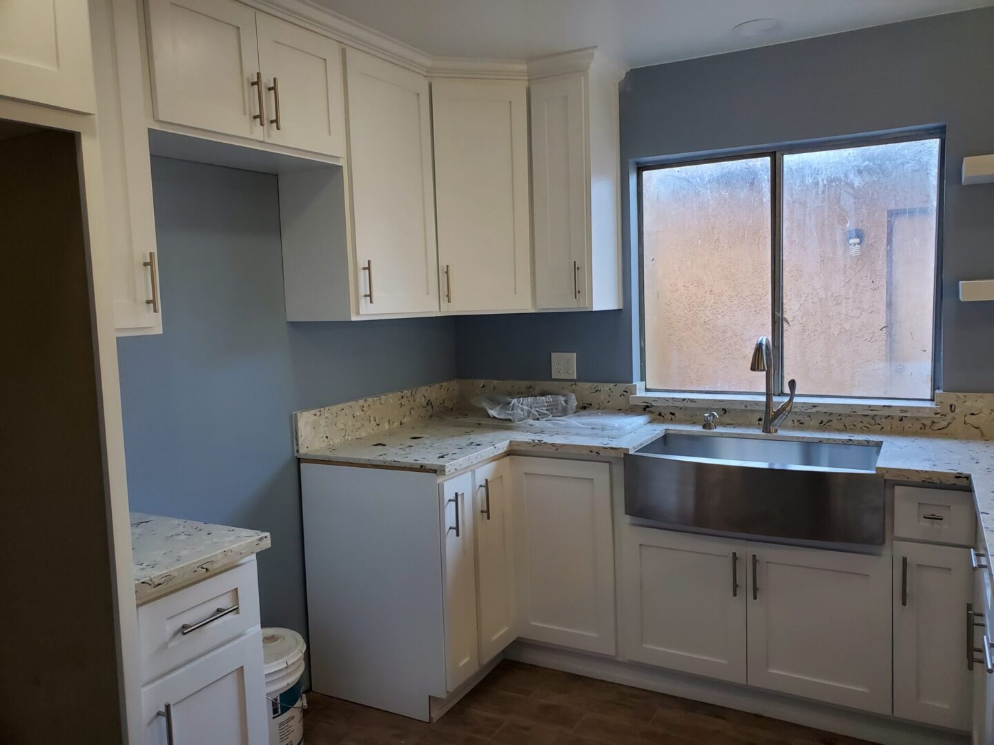 A kitchen with white cabinets and blue walls.